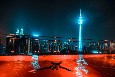 Swimming in an illuminated pool at night in the city