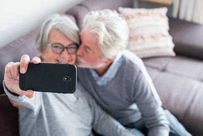Midsection of man holding mobile phone