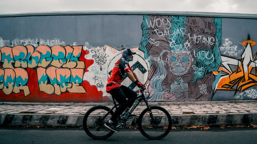 Graffiti on bicycle against wall in city