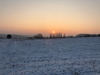 Scenic view of frozen lake against clear sky during sunset