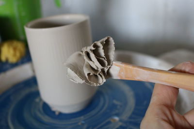 Close-up of hand holding coffee cup