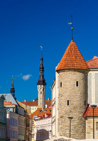 Church amidst buildings against clear blue sky