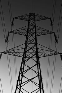 Low angle view of electricity pylon against clear sky