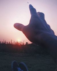 People on field against sky at sunset