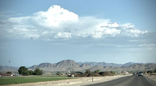 Road by mountains against sky