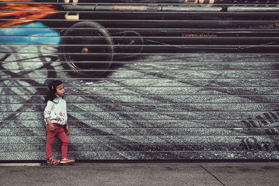 Close-up of girl standing against wall 