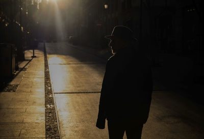 Silhouette of adult man in hat on street during sunset. madrid, spain