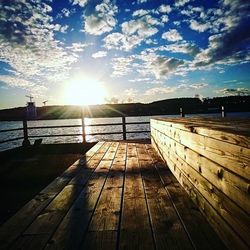 Pier on sea against sky during sunset