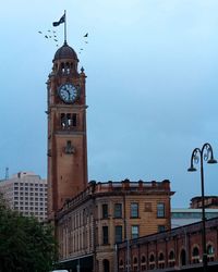 Low angle view of clock tower in city against sky