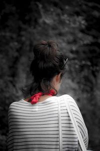 Rear view of woman standing against wall