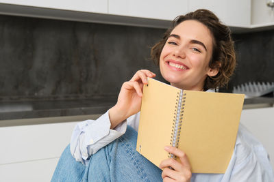 Portrait of young woman reading book