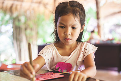 Close-up of cute girl making artwork at workshop