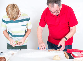 People making cookies on table at home