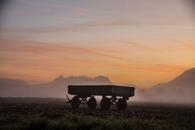 Silhouette horse on field against sky during sunset