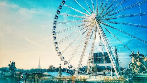 Low angle view of ferris wheel against blue sky