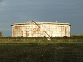 Factory on field against sky