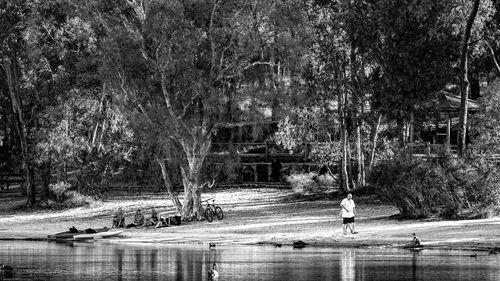 Man and woman by river against trees