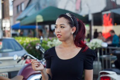 Close-up of young woman looking away while standing on street