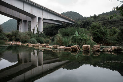 Arch bridge over river against sky