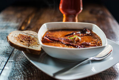 Close-up of soup with toasted bread on wooden table