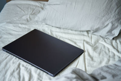 Close-up of laptop on bed