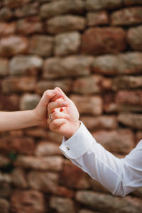 Midsection of couple holding hands