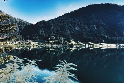 Scenic view of lake by mountains against sky