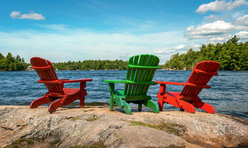 Colorful deck chairs at waters edge, view of blue skies and cottage country from bedrock