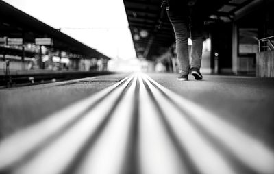 Low section of person walking on railroad station