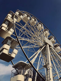 Low angle view of ferris wheel against blue sky