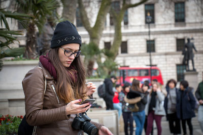 Portrait of young woman in city during winter