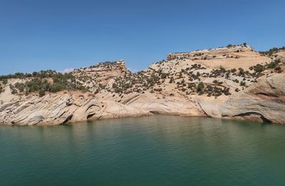 Scenic view of rock formations against clear blue sky