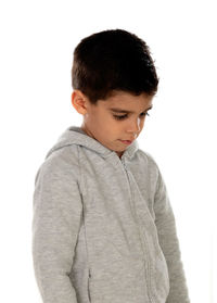 Boy looking away while standing against white background