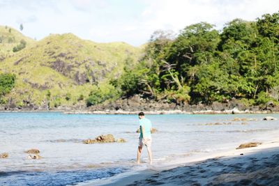 Full length of man standing on beach against sky