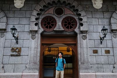 Portrait of young woman standing outside temple