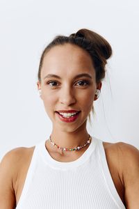 Portrait of smiling young woman against white background