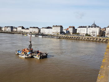 High angle view of boats in river against buildings