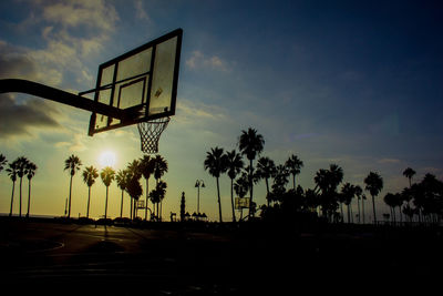 Silhouette of basketball hoop against sky during sunset