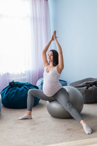 Full length of woman sitting at home