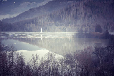 Scenics view of lake and trees in foggy weather