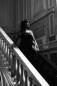 Woman looking down while standing on staircase