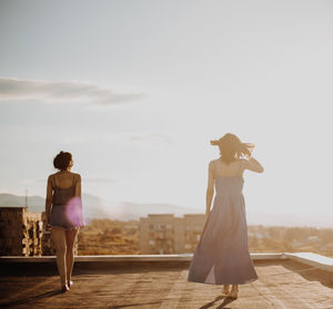 Female friends walking on terrace during sunset