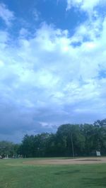 Scenic view of grassy field against cloudy sky