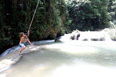 Woman jumping in pond
