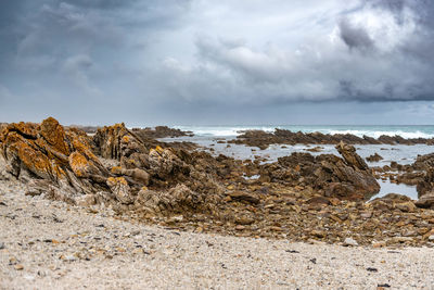 Rocks on beach against sky