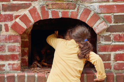 Pretty young girl playing with a brick stove at a farming exhibition