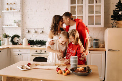 Family with children having fun and laughing while preparing for the christmas holiday in kitchen