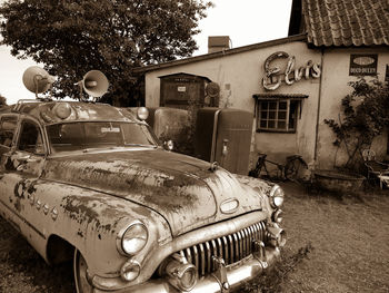 Abandoned car parked against trees