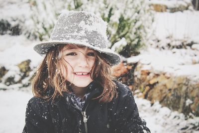 Portrait of beautiful young woman standing in snow