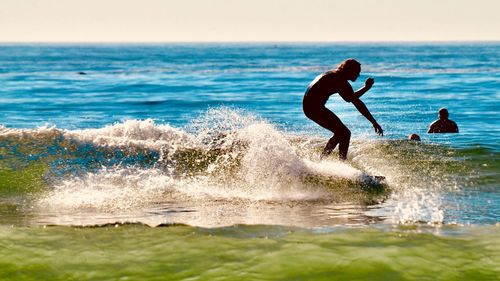 People playing on beach against sea